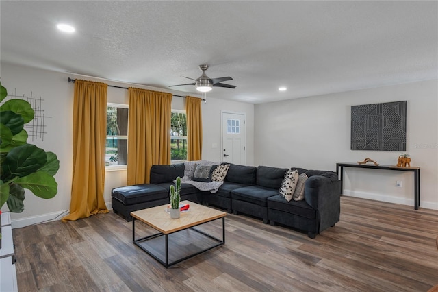 living room with a textured ceiling, hardwood / wood-style flooring, and ceiling fan