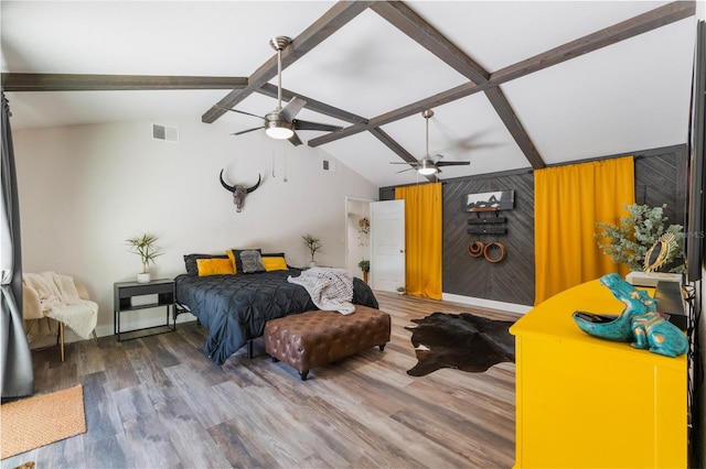 bedroom with hardwood / wood-style floors, ceiling fan, wooden walls, and lofted ceiling with beams