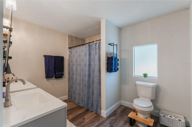 bathroom featuring toilet, vanity, hardwood / wood-style floors, and walk in shower