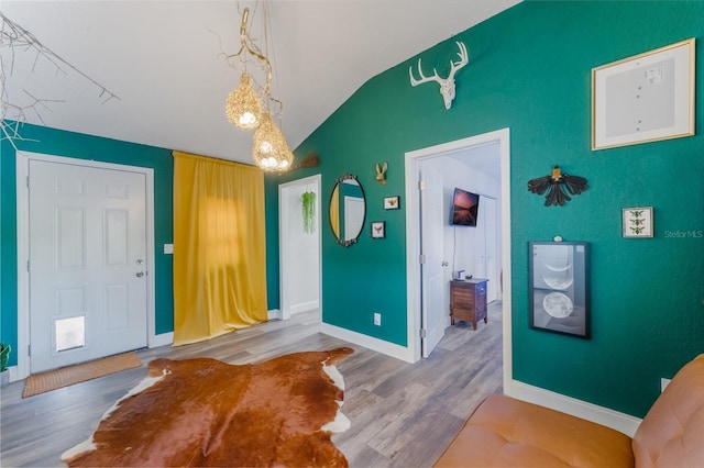 foyer with vaulted ceiling and hardwood / wood-style flooring