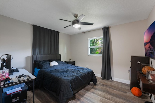 bedroom with hardwood / wood-style floors, ceiling fan, and a textured ceiling