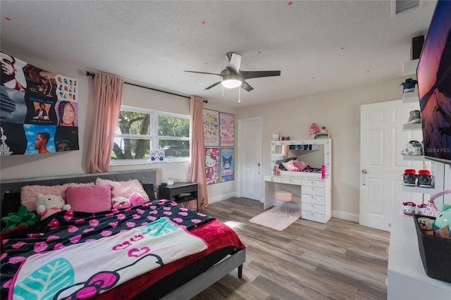 bedroom featuring a textured ceiling, hardwood / wood-style floors, and ceiling fan