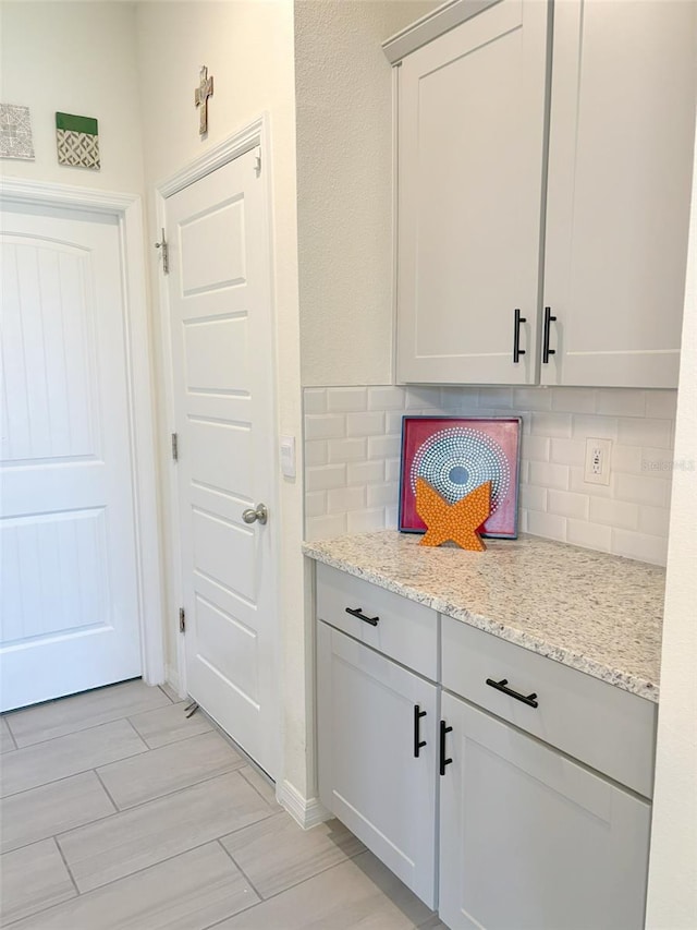 kitchen featuring light stone counters and backsplash