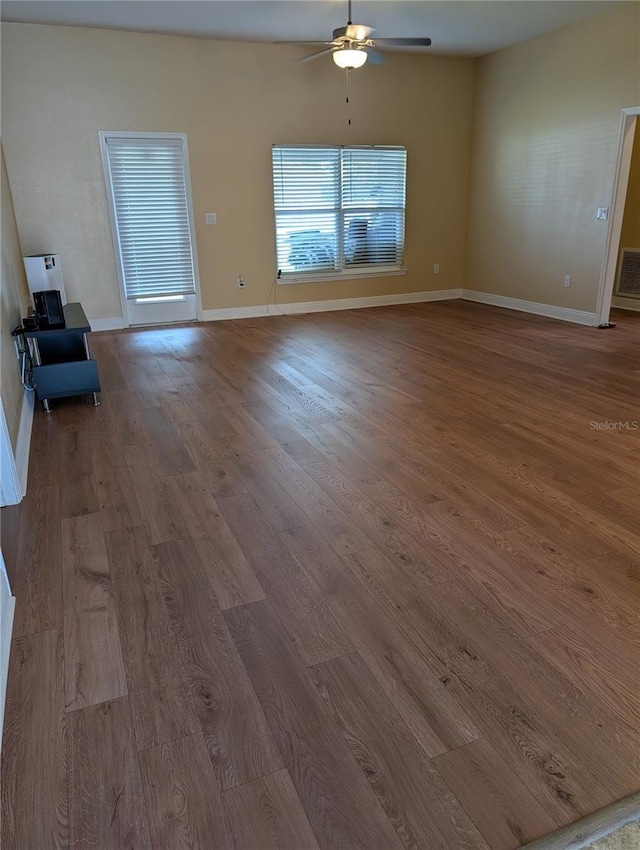 unfurnished living room with ceiling fan and wood-type flooring