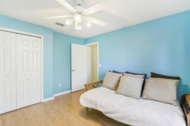 bedroom featuring light hardwood / wood-style floors, ceiling fan, and a closet