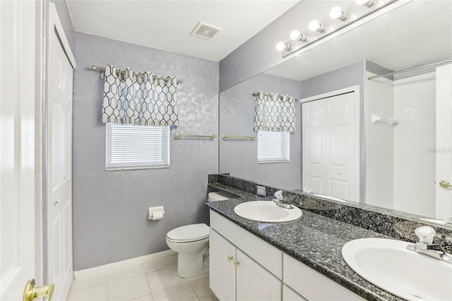 bathroom featuring vanity, tile patterned flooring, plenty of natural light, and toilet