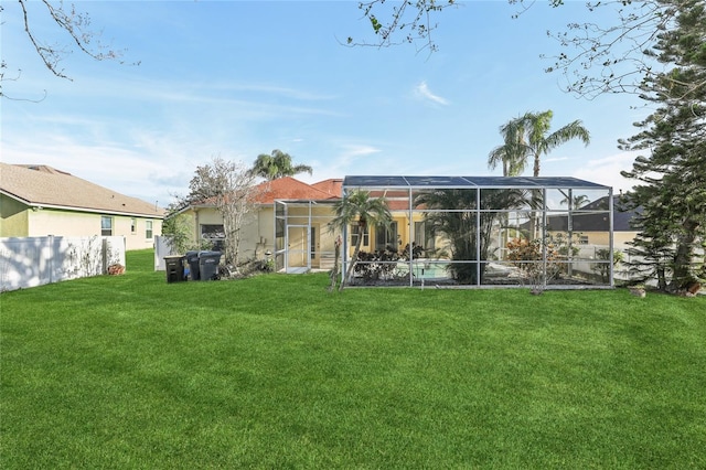 rear view of property featuring a lanai and a yard