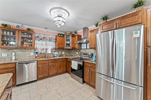 kitchen featuring wall chimney exhaust hood, stainless steel appliances, ornamental molding, sink, and light stone countertops