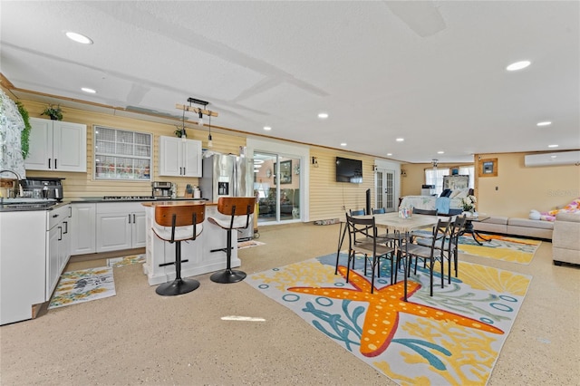 dining room featuring sink, ornamental molding, a textured ceiling, and a wall unit AC