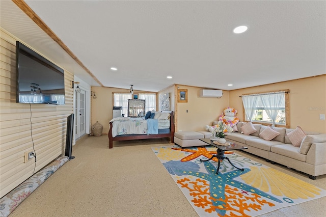 living room with an AC wall unit, vaulted ceiling, and plenty of natural light