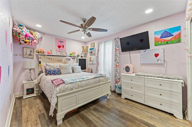 bedroom featuring dark wood-type flooring, a textured ceiling, and ceiling fan