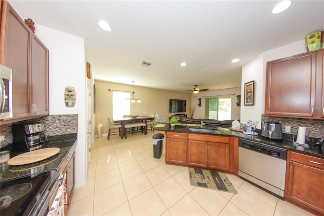 kitchen with light tile patterned floors, stainless steel appliances, backsplash, and ceiling fan