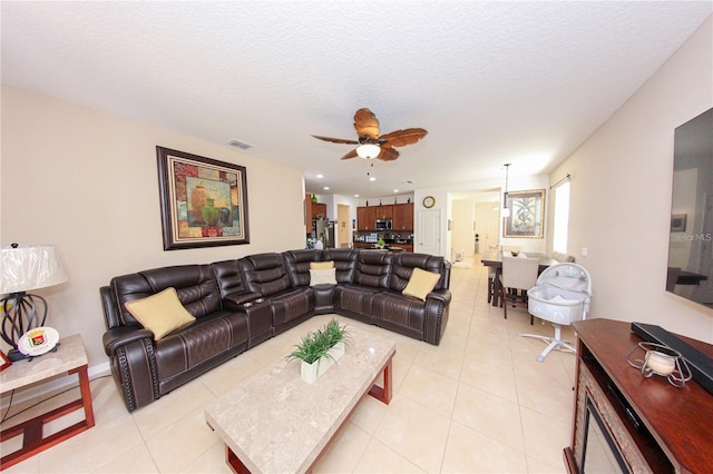 tiled living room with a textured ceiling and ceiling fan