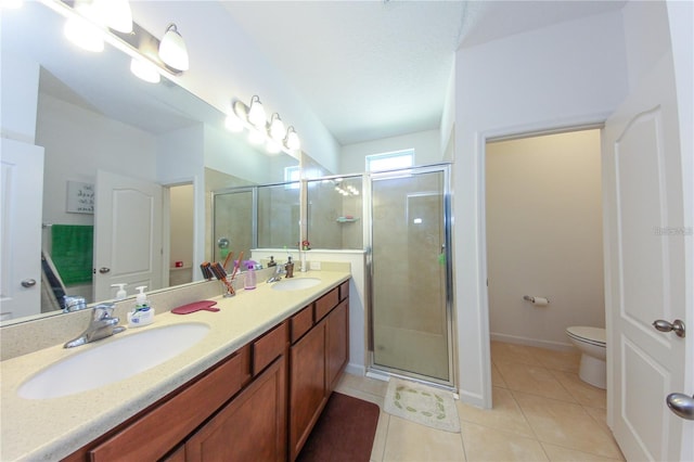 bathroom with toilet, vanity, tile patterned floors, and a shower with door