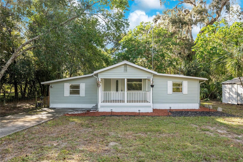 view of front facade with a front yard and covered porch