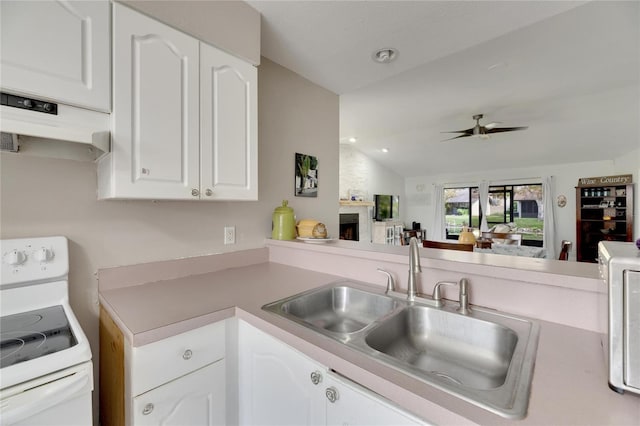 kitchen with a large fireplace, white cabinetry, ceiling fan, white stove, and lofted ceiling