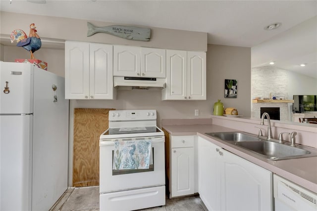 kitchen with lofted ceiling, a stone fireplace, sink, white cabinetry, and white appliances