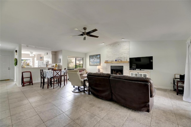 living room with vaulted ceiling, a fireplace, a healthy amount of sunlight, and ceiling fan