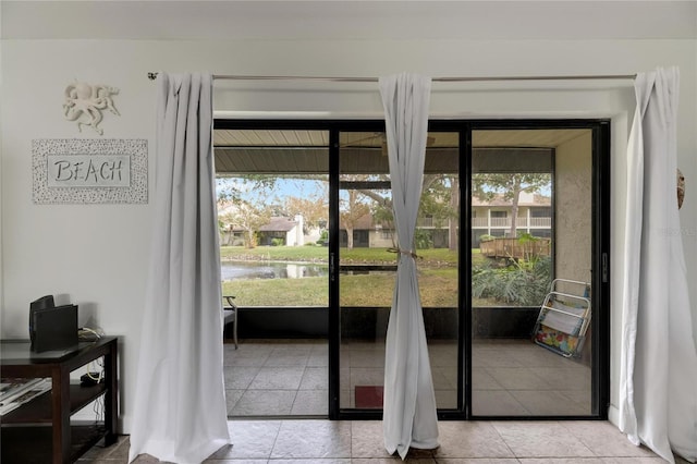 entryway featuring a water view and light tile patterned floors