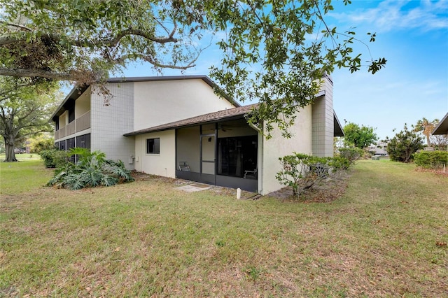 back of house with a lawn and ceiling fan