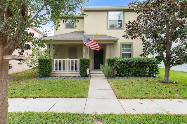 traditional-style home with a porch, a front lawn, and stucco siding