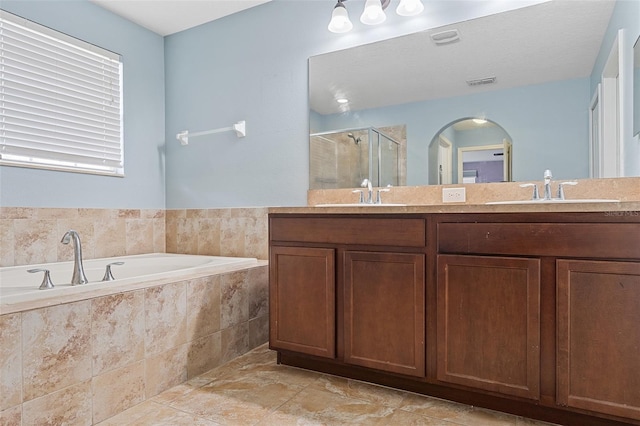 bathroom with a garden tub, a sink, visible vents, and a shower stall