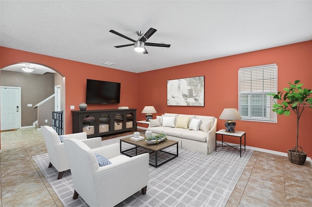 tiled living room featuring ceiling fan and a textured ceiling