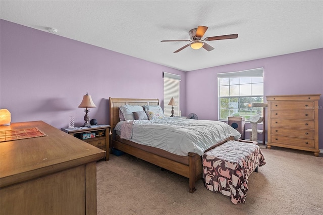 bedroom with light carpet, ceiling fan, and a textured ceiling