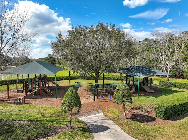 view of home's community featuring playground community and a yard