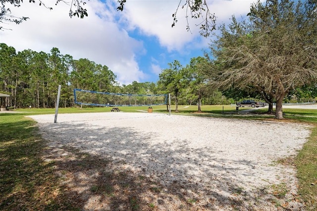 view of property's community with volleyball court and a lawn