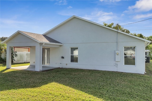 rear view of house with a patio and a lawn