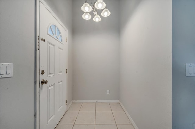 tiled foyer entrance with an inviting chandelier