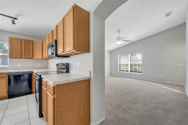 kitchen featuring vaulted ceiling, track lighting, black appliances, light carpet, and ceiling fan