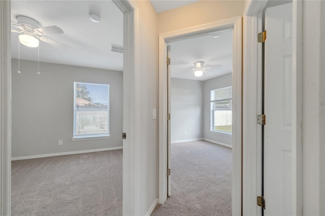 hall with plenty of natural light and light colored carpet