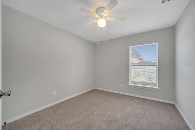 carpeted spare room featuring ceiling fan