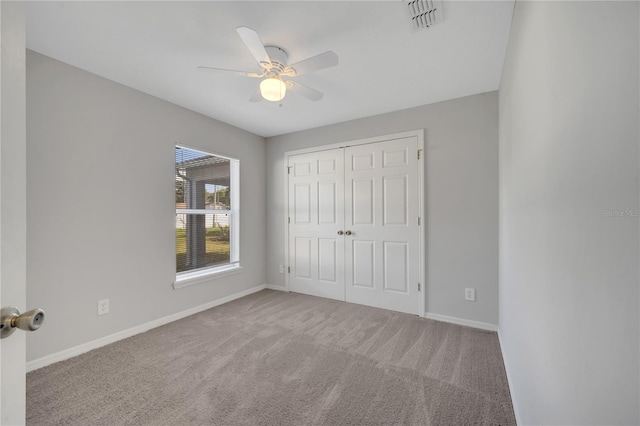 unfurnished bedroom featuring ceiling fan, a closet, and carpet floors