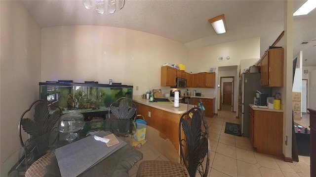 kitchen with lofted ceiling, sink, an inviting chandelier, and light tile patterned floors