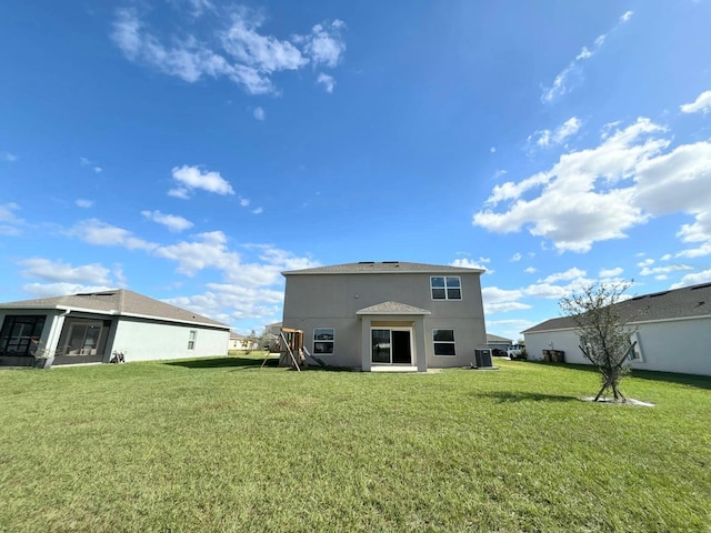 back of property featuring central air condition unit and a lawn