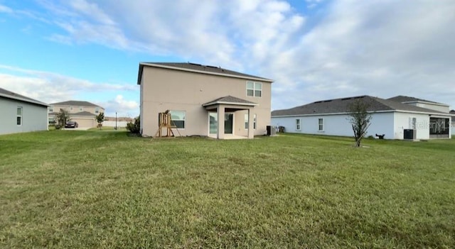 rear view of house with a yard and central air condition unit