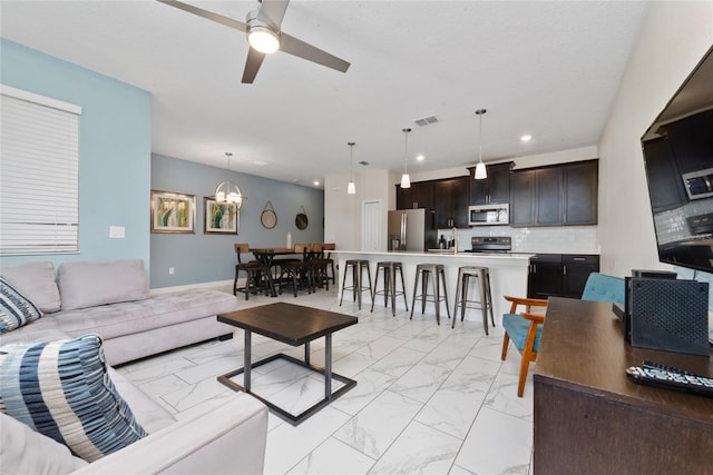 living room with sink and ceiling fan with notable chandelier