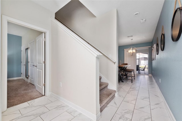 stairway featuring carpet and an inviting chandelier