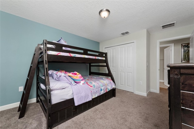 carpeted bedroom featuring a textured ceiling and a closet