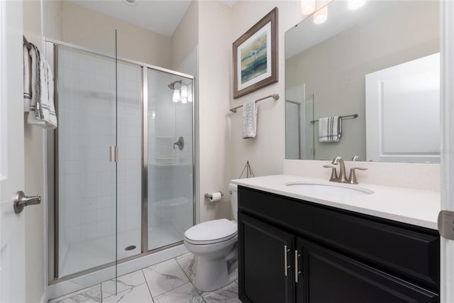 bathroom featuring toilet, vanity, and a shower with door