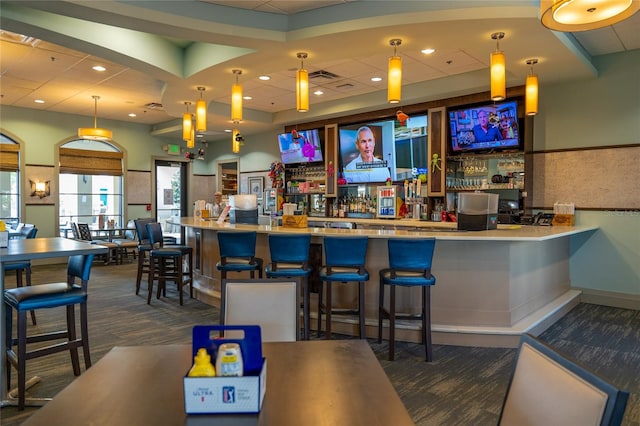 bar with pendant lighting and dark carpet