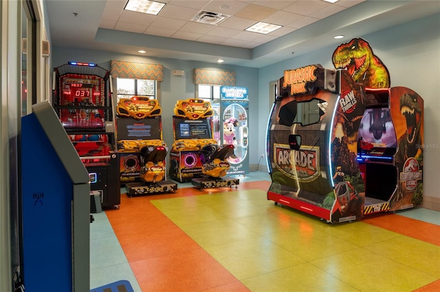 game room featuring a paneled ceiling and a raised ceiling