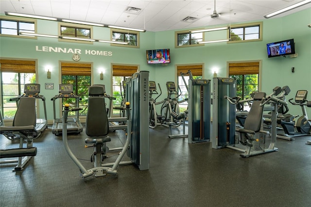 workout area featuring a towering ceiling and a drop ceiling