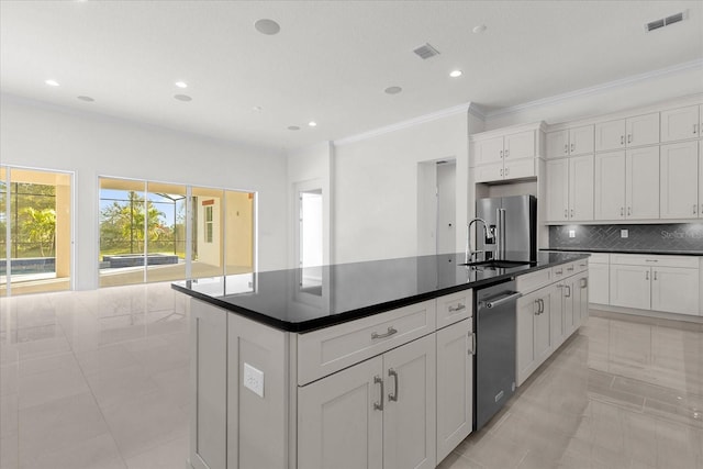 kitchen with white cabinets, backsplash, a kitchen island with sink, high quality fridge, and sink