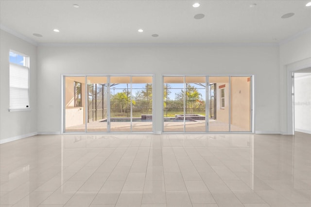 tiled empty room featuring ornamental molding and a healthy amount of sunlight