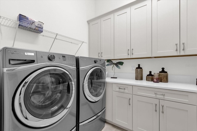 washroom featuring cabinets and separate washer and dryer