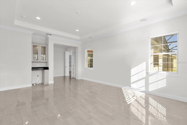 unfurnished living room with ornamental molding, light tile patterned floors, and a raised ceiling